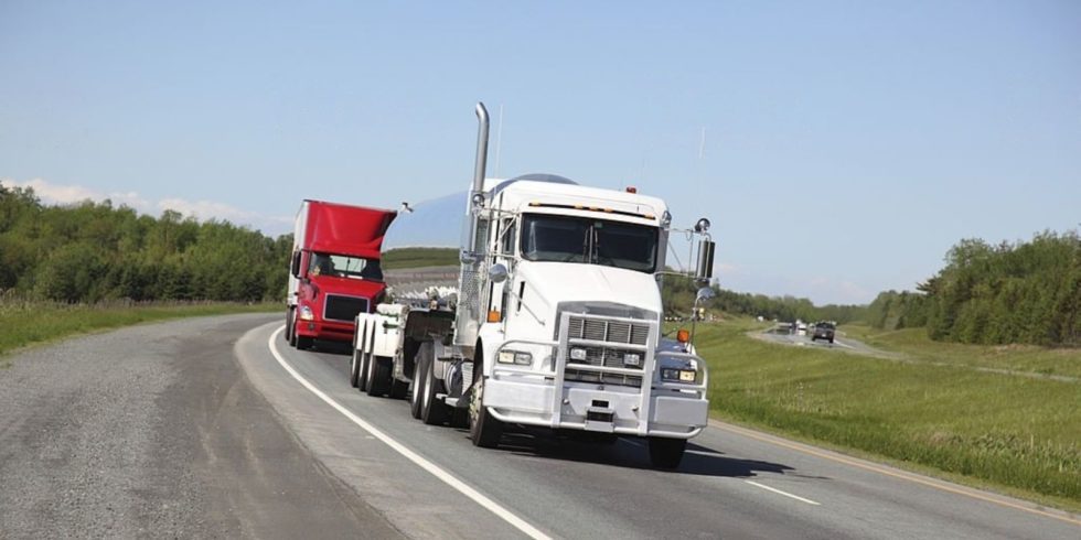 How To Cut Costs in the Trucking Business IN USA:
A white truck and red fleet travel on the road